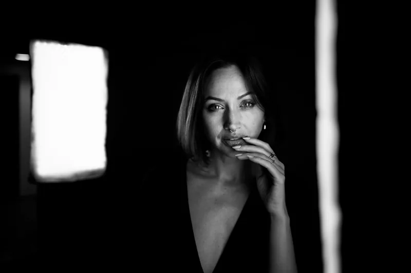 Retrato en blanco y negro de una mujer iluminada por una ventana