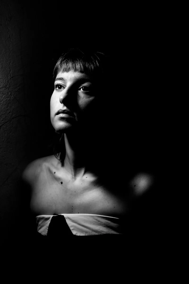 Retrato de estudio en blanco y negro de una mujer en claroscuro