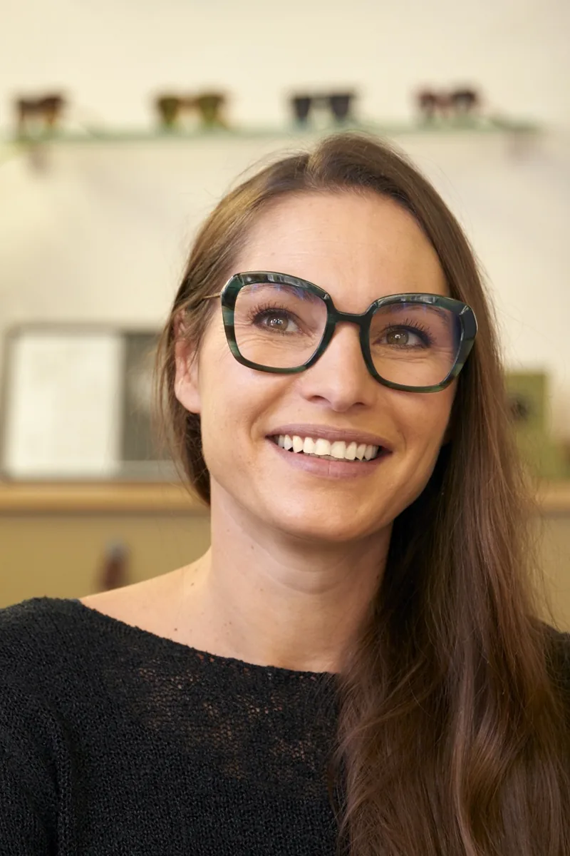 Retrato en situación de una óptica sonriente en su tienda