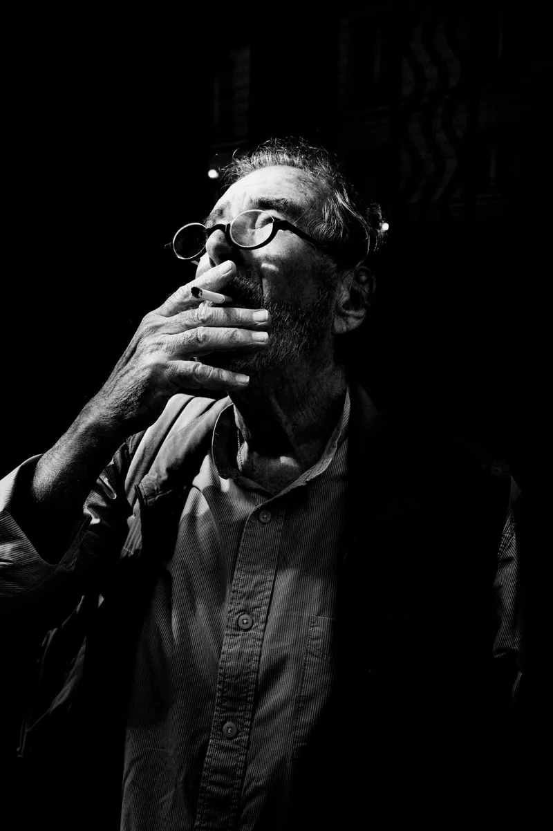 Man lighting a cigarette in the shadows, black and white